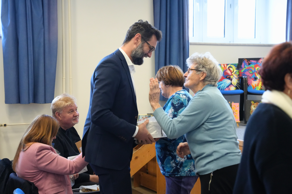 primátor si podáva ruku a rozpráva sa so seniorkou