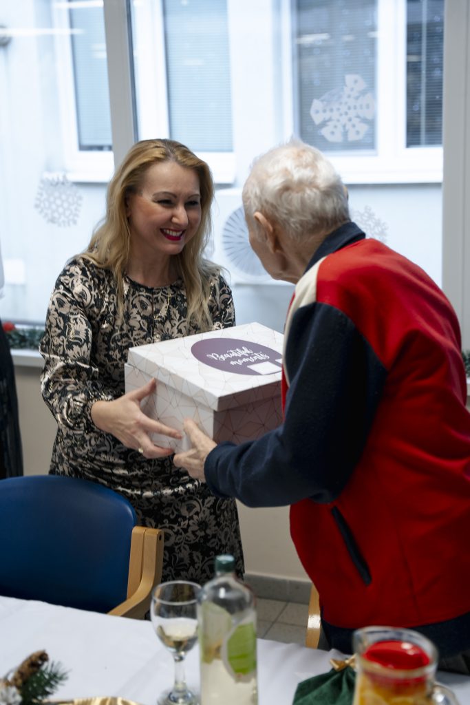 Odovzdávanie vianočného darčeka seniorke. 