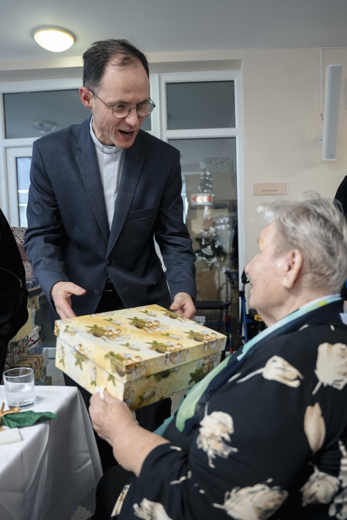 Senior prijímajúci darčekovú krabicu. 