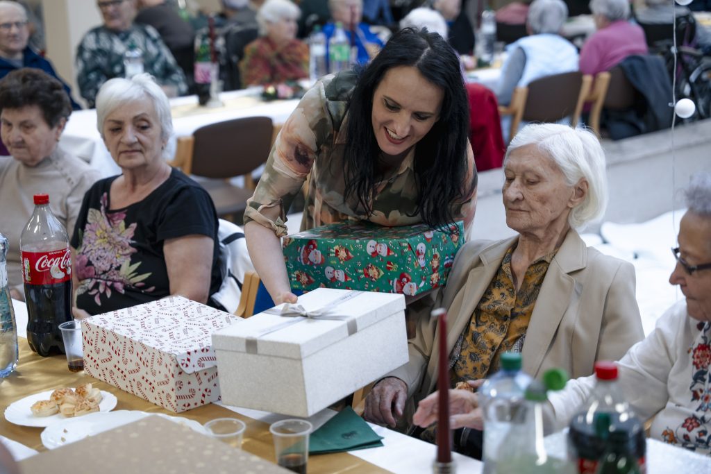 Odovzdávanie darčekovej krabice seniorke. 