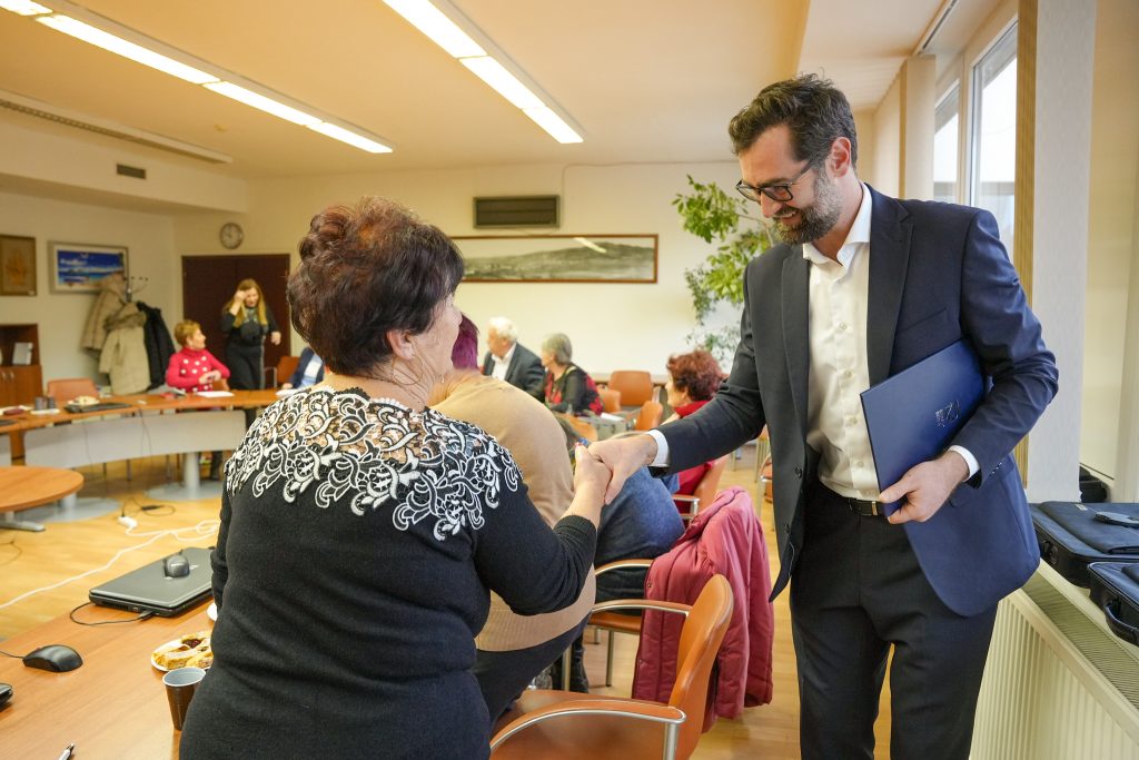 muž-primátor podáva ruku seniorke