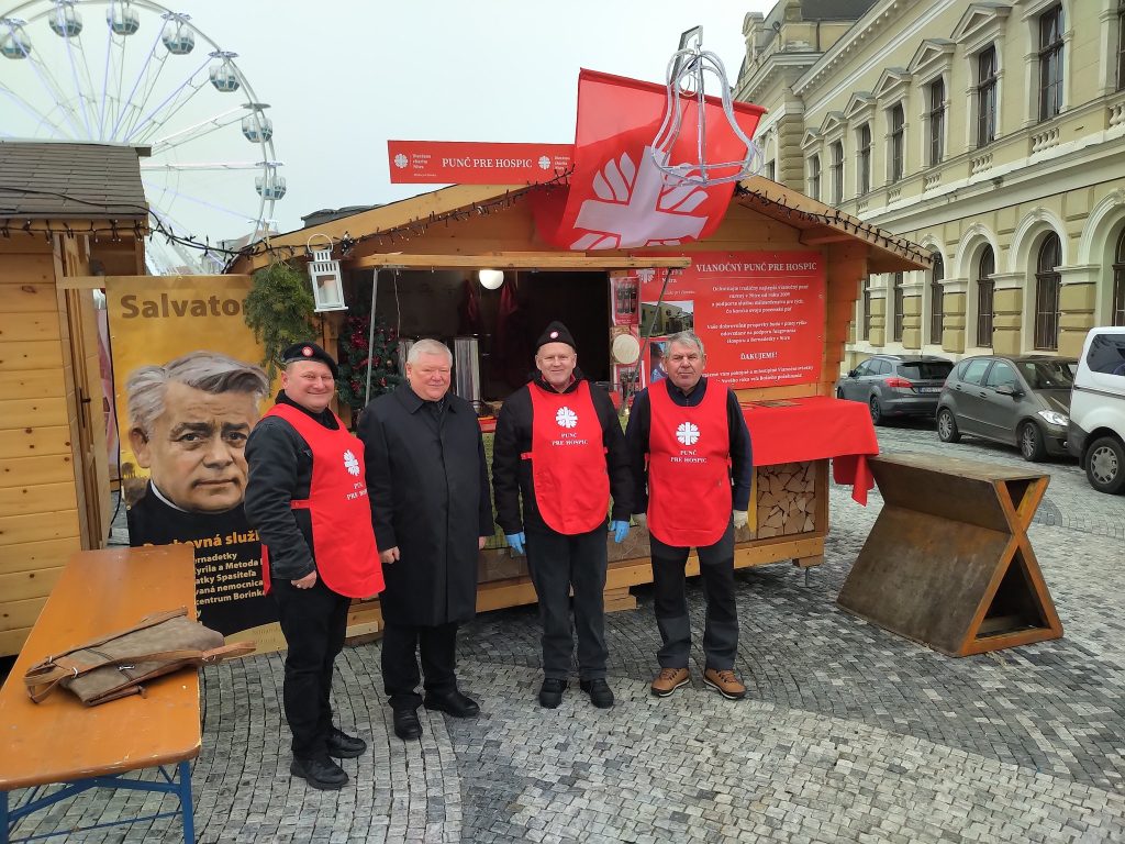 Štyria muži vrátane nitrianskeho biskupa Viliama Judáka pred dreveným stánkom s červenými banermi