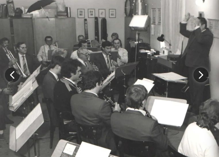 hráči dychovky s dirigentom