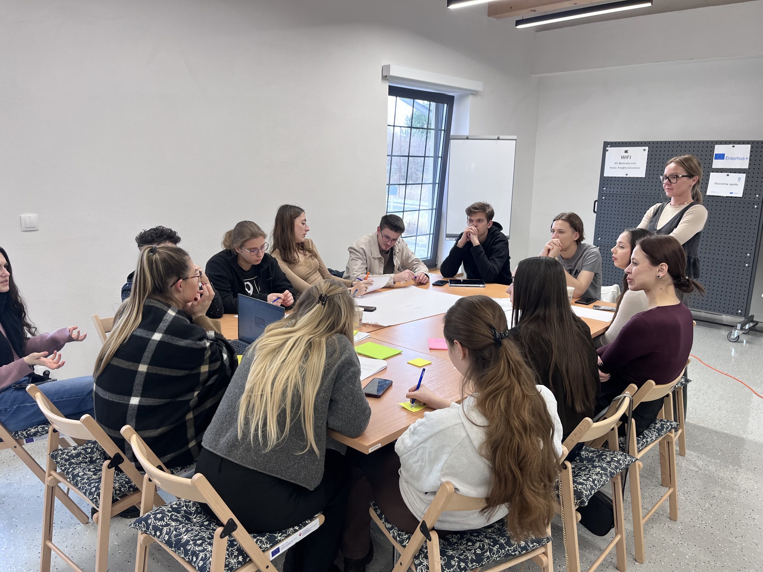 Mladí ľudia sedia a diskutujú